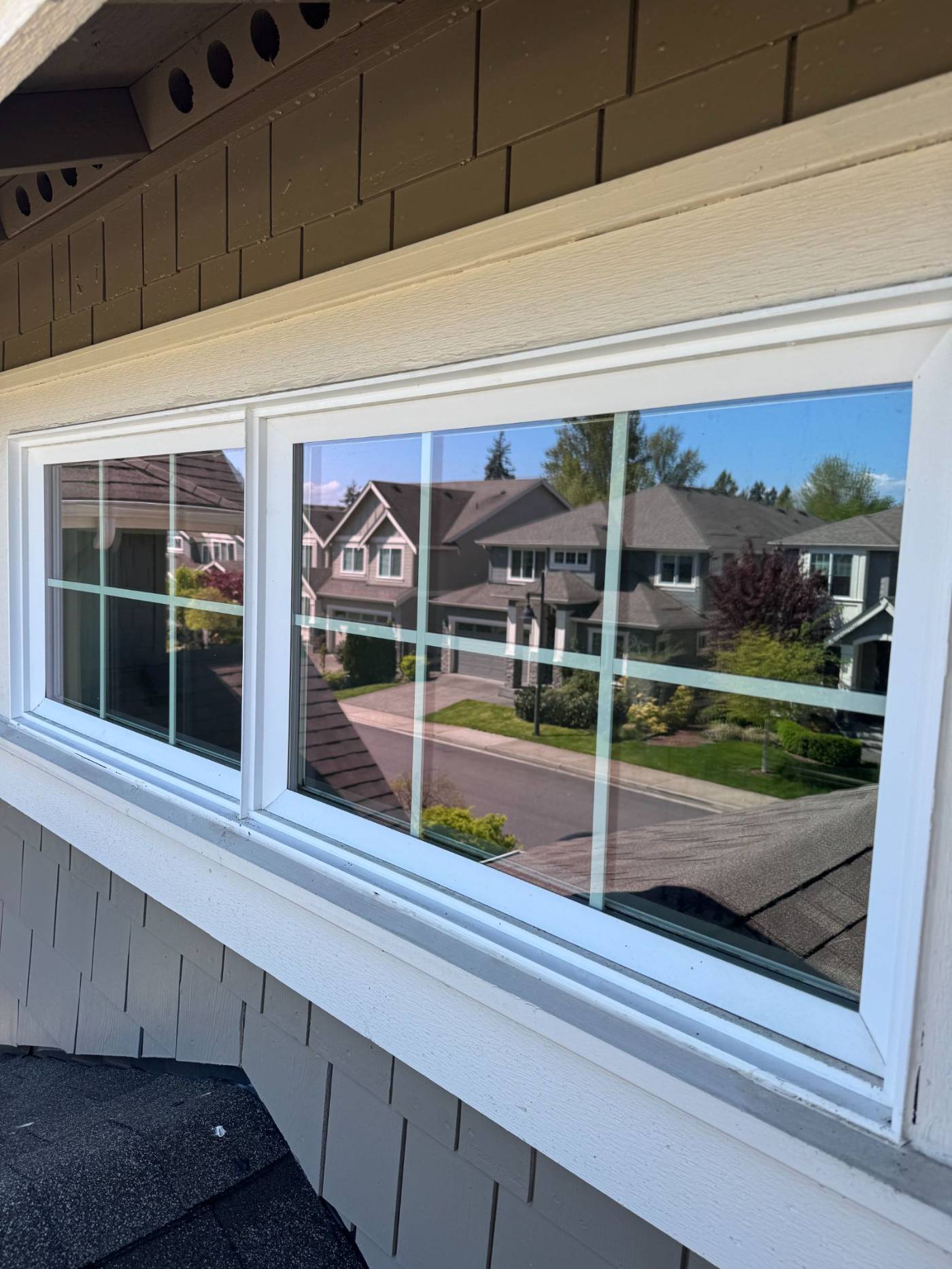 Clean exterior window with crisp reflection of the neighborhood after professional window cleaning